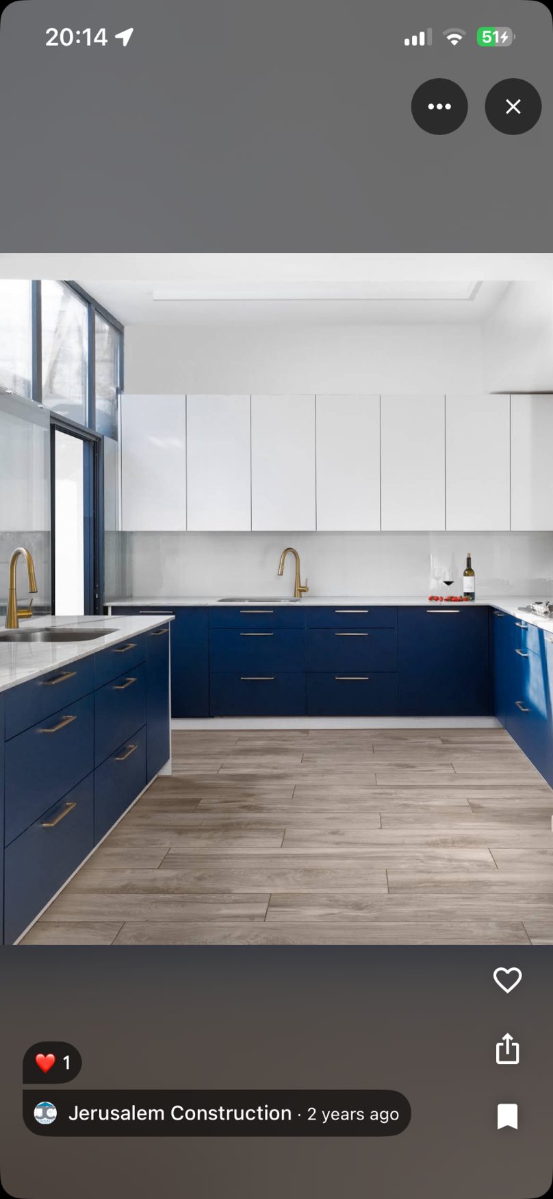 Deep blue kitchen with gold faucet and white marble countertops